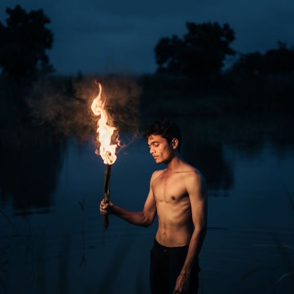 Silhouette of a man in a balanced pose against a dark background.